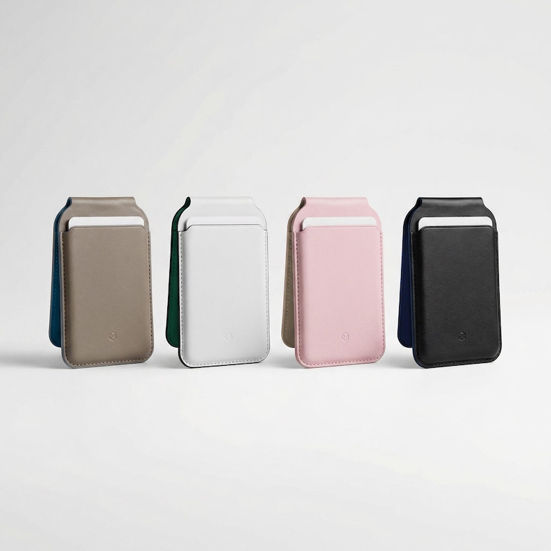 May include: Four leather phone card holders in a row. The colours are taupe, white, pink, and black. Each holder has a slot for cards and a contrasting coloured back panel. The holders are standing upright against a white background.