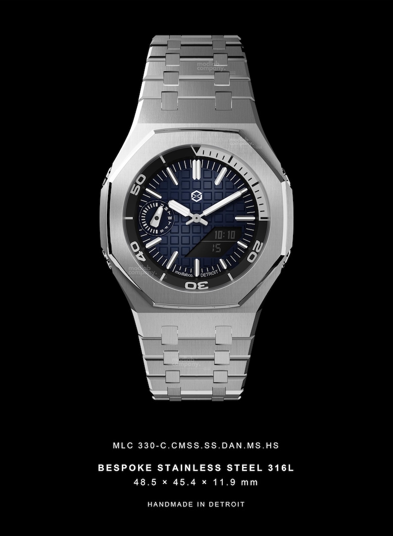 May include: A stainless steel wristwatch with a blue face and silver hands. The watch has a rectangular case and a matching stainless steel band. The watch face displays the time and other information. The watch is 48.5 x 45.4 x 11.9 mm. Text on the watch reads "BESPOKE STAINLESS STEEL 316L" and "HANDMADE IN DETROIT."