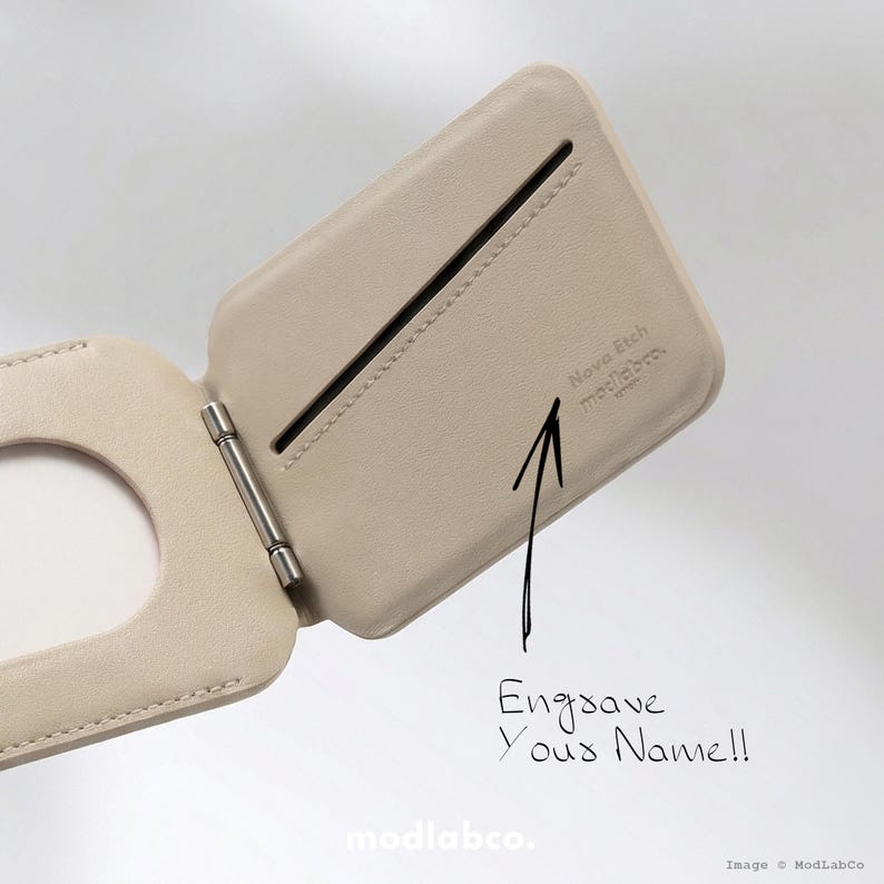 Puede incluir: Cartera de cuero beige claro abierta, con una bisagra plateada. La cartera tiene una ranura y el texto "Engrave Your Name!!" est&aacute; escrito en la imagen. La marca "modlabco." es visible en la parte inferior.