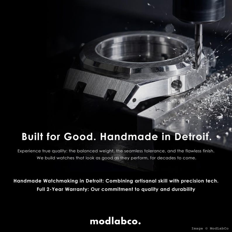 May include: A close-up of a watch component being machined. The text "Built for Good. Handmade in Detroit" is visible. The image highlights the precision and craftsmanship of watchmaking.