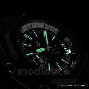 May include: Black wristwatch with a dark green face and glowing green hands and markers. The watch face displays the time as 10:10 and the word "DETROIT". The watch has the text "modlabco." and "Copyright &copy; modlabcompany 2024".