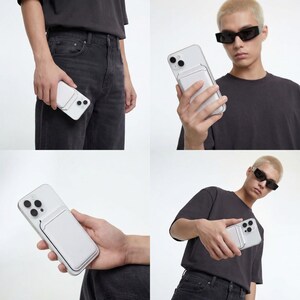 May include: A white smartphone with a white cardholder attached. The phone has a clear case and a rectangular cardholder on the back. The phone is held in various positions, showcasing its design and functionality.