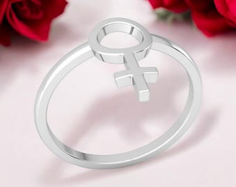 Puede incluir: Un anillo de plata con un diseño de símbolo femenino. El anillo es simple y elegante.