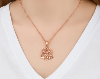 Op de afbeelding: Een roségouden ketting met een Keltische knoop hanger. De hanger is een gestileerde drieledige knoop in een cirkel, hangend aan een fijne ketting. De ketting wordt getoond tegen een witte achtergrond.