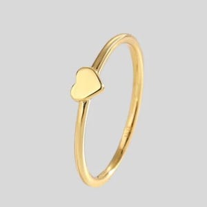 May include: A simple gold ring with a small heart-shaped design.