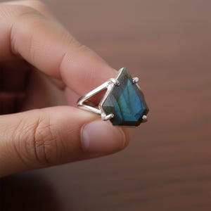 May include: A set of three ceramic mugs with a speckled, matte finish. The mugs are in shades of cream, light gray, and dark gray. Each mug has a simple, minimalist design and a rounded handle. The mugs are likely for coffee or tea.