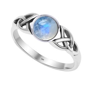 May include: A silver ring featuring a Celtic knot design and a round, iridescent moonstone.