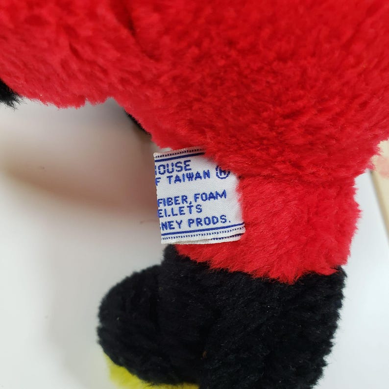 Pode incluir: Brinquedo de pel&uacute;cia vermelho e preto com uma etiqueta branca que diz "House of Taiwan (R) Fiber, Foam Pellets Disney Prods."