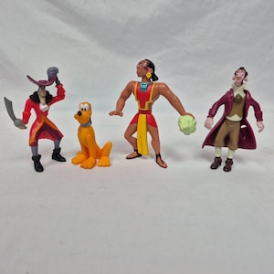 May include: A collection of colorful plastic figurines featuring characters from Disney movies. The figures include Captain Hook in a red coat, Pluto the dog, a character in red and yellow attire, and a man in a purple coat.