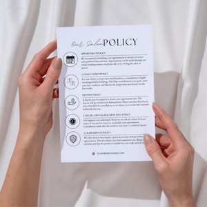 Peut inclure: Une feuille de papier blanche avec le texte "Our Salon Policy" en écriture élégante. Le document détaille les politiques de rendez-vous, de consultation, de dépôt, d'annulation et de service de couleur. Le papier est tenu par deux mains.