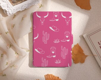 May include: A pink e-reader cover with a white cowboy boot, cactus, skull, and hat pattern.
