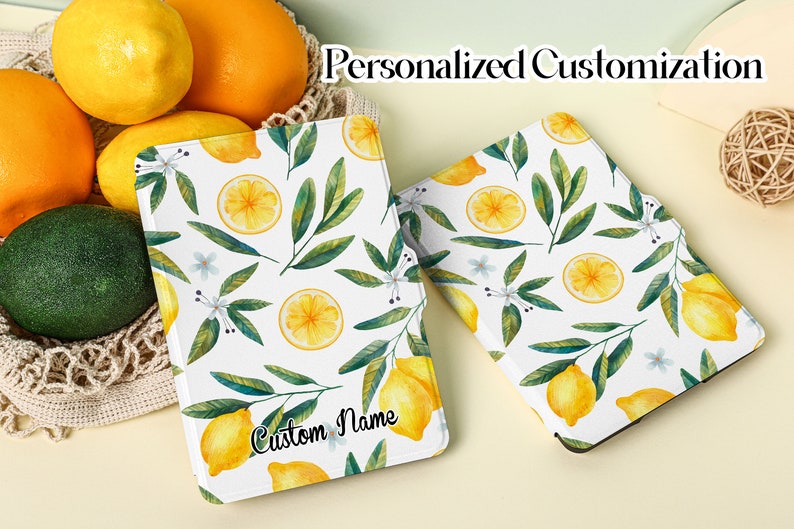 May include: A white e-reader cover with a lemon and leaf pattern. The cover has the text "Custom Name" printed on it.  Personalized Customization.