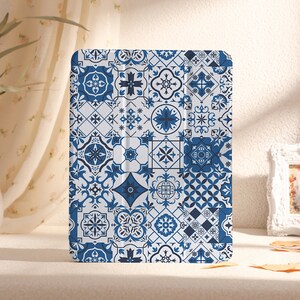 Può includere: Una custodia per iPad con un motivo geometrico blu e bianco. La custodia è realizzata in un materiale resistente e presenta un design elegante.