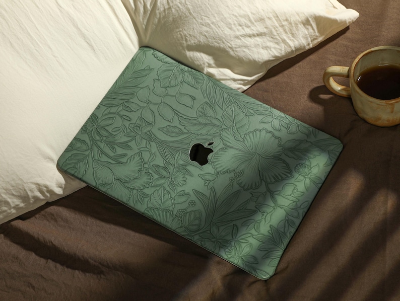 May include: A green laptop skin with a floral design. The skin has a raised texture and features a subtle embossed apple logo.