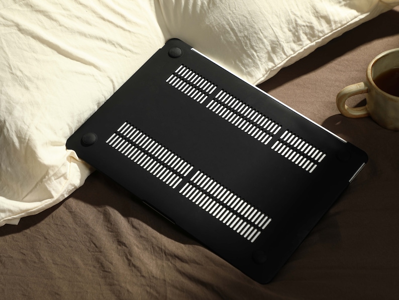 May include: Black laptop case with a textured, vented design. The case is made of hard plastic and has a smooth, matte finish.
