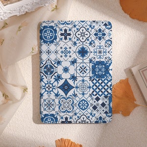 Puede incluir: Una funda para teléfono con un diseño de azulejos azul y blanco. El diseño presenta una variedad de formas geométricas y patrones.