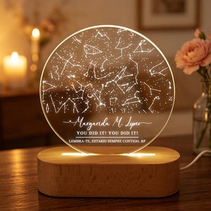 Könnte beinhalten: Ein kreisförmiges Acryl-Nachtlicht mit einer eingravierten Sternenkarte. Der Sockel besteht aus hellem Holz. Der Text lautet: Margarida M. Lopes, YOU DID IT! YOU DID IT!, LEMBRA-TE, ESTAREI SEMPRE CONTIGO, RP.