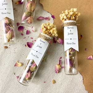 May include: Three small glass vials filled with dried flowers and rose tea. Each vial has a white label with the text "Romeo & Juliet" and "Rose Tea".