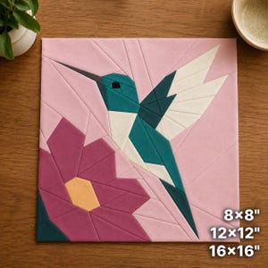 Könnte beinhalten: Ein geometrischer Stoff-Quiltblock mit einem Kolibri in Blaugrün, Dunkelgrün und Weiß, der über einer großen magentafarbenen Blume mit gelber Mitte vor einem hellrosa Hintergrund schwebt. Text gibt die Größen 8x8, 12x12 und 16x16 Zoll an.