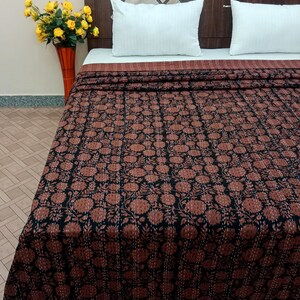 Könnte beinhalten: Eine schwarze und braune Kantha-Steppdecke mit floralem Muster. Die Steppdecke ist aus Baumwolle und handgenäht. Es ist eine traditionelle indische Steppdecke, die für ihre Langlebigkeit und Schönheit bekannt ist.