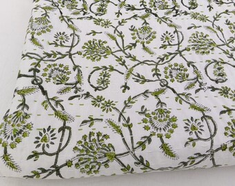 Könnte beinhalten: Ein weißer Stoff mit einem sich wiederholenden Blumenrankenmuster in Olivgrün und Dunkelgrau. Das Textil weist sichtbare horizontale Steppnähte in hellgrünem Garn auf, die dem Stoff eine gesteppte Textur verleihen.