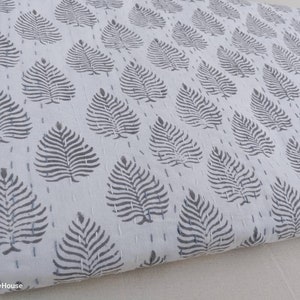 May include: White cotton fabric with a repeating pattern of gray leaf designs. The fabric is folded and has a subtle texture.