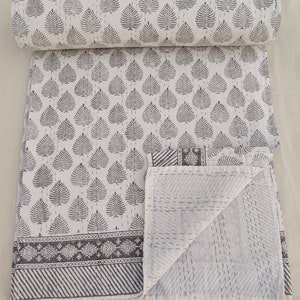 May include: White cotton quilt with a gray leaf pattern and a gray border. The quilt is folded in half and the inside is visible, showing a white cotton fabric with a diamond pattern.
