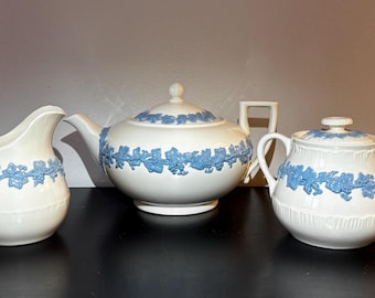 May include: A white teapot, creamer, and sugar bowl with blue floral designs. The set is made of fine china and is perfect for a tea party.