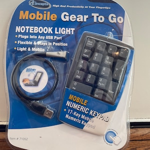 May include: A black and gray mobile numeric keypad with a USB cable and a small light. The keypad has 17 keys and is labeled "Mobile Numeric Keypad". The packaging is blue and white and says "High End Productivity At Your Fingertips" and "Mobile Gear To Go".