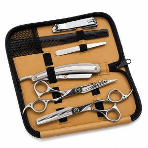 Peut inclure: Un kit de toilettage dans un étui zippé beige contenant un rasoir droit argenté, deux paires de ciseaux de coiffure argentés avec des accents verts, un peigne noir, une pince à épiler et un coupe-ongles argentés, fixés par des élastiques noirs.