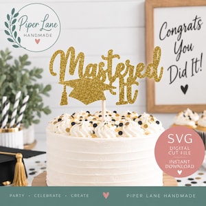 May include: A gold glitter cake topper featuring the text Mastered It with a graduation cap icon, mounted on a wooden stick. The topper is displayed on a white frosted cake decorated with black and gold confetti, with a sign reading Congrats You Did It.