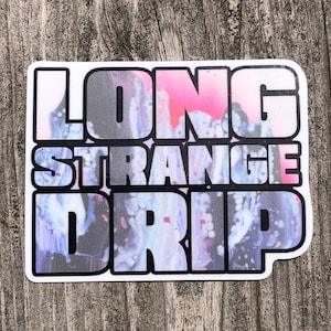 May include: A sticker with a colorful, abstract design featuring the words "LONG STRANGE DRIP" in white letters.