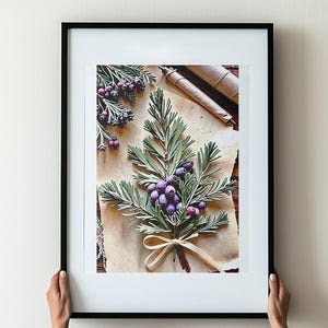 May include: A framed artwork featuring a botanical arrangement. The artwork showcases a bouquet of green leaves and purple berries tied with a beige ribbon. The background is a textured, parchment-like paper, and the frame is black.