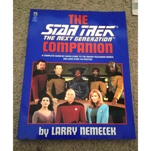 Puede incluir: Una cubierta de libro azul con el título "The Star Trek: The Next Generation Companion" y una foto del elenco principal. El libro es de Larry Nemecek e incluye más de 150 fotos.