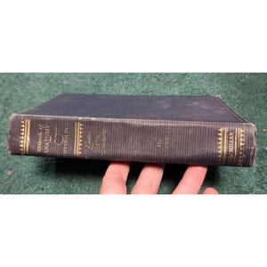 Op de afbeelding: Een donkerblauw hardback boek getiteld "Textbook of Anatomy and Physiology" door Leslie B. Arey. Het boek is de 11e editie en heeft gouden letters op de rug.