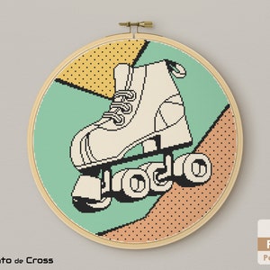 May include: A cross-stitch pattern featuring a white roller skate with black wheels on a colorful geometric background. The background includes shades of green, yellow, orange, and brown.