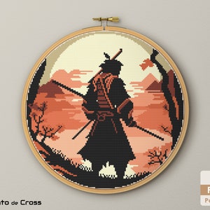 May include: Cross stitch pattern of a samurai warrior standing in a mountainous landscape with a sunset in the background. The pattern is in a hoop and is ready to be stitched.