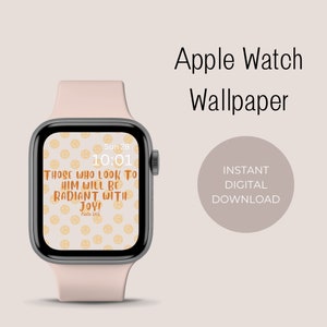 Op de afbeelding: Een roze Apple Watch met een witte wijzerplaat en een digitale klok die 10:01 aangeeft. De wijzerplaat van het horloge heeft een patroon van gele smiley-gezichten en de tekst "Those who look to him will be radiant with joy! Psalm 345".