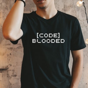 May include: A black t-shirt with the text "[CODE] BLOODED" in white pixelated font.