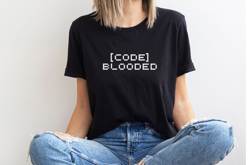 May include: A black t-shirt with white text that reads "[CODE] BLOODED" in a pixelated font.