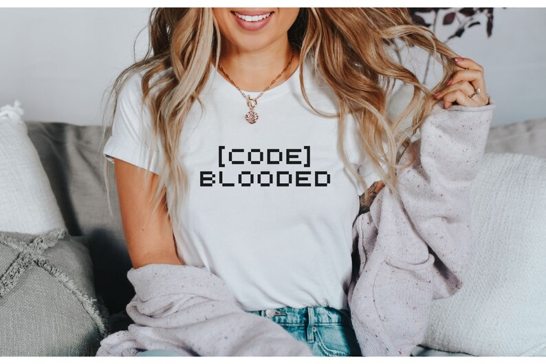 K&ouml;nnte beinhalten: Wei&szlig;es T-Shirt mit dem Text "[CODE] BLOODED" in Schwarz gedruckt.