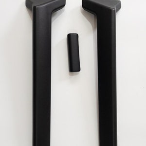 May include: Two black plastic door handles with a triangular top and a smaller black plastic handle.