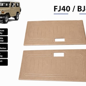May include: Two rectangular tan interior door panels for a Toyota FJ40 or BJ40 vehicle. Each panel features a smooth surface with a recessed rectangular border, vertical embossed lines, and a central rectangular cutout for a door handle.