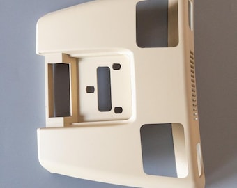 May include: A beige plastic car interior trim piece with several cutouts and a textured surface.