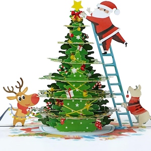 Carte pop-up 3D du Père Noël décorant un sapin de Noël. Une délicieuse carte de voeux surprise pour les enfants, les amis et la famille. 15 cm x 15 cm