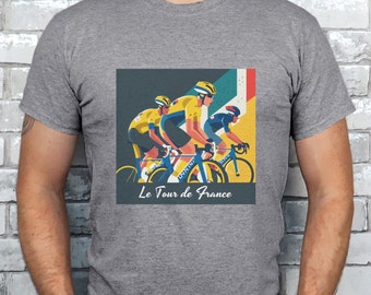 Op de afbeelding: Een grijs T-shirt met een afbeelding van drie fietsers in gele en blauwe truien die fietsen. De afbeelding bevat de tekst "Le Tour de France".