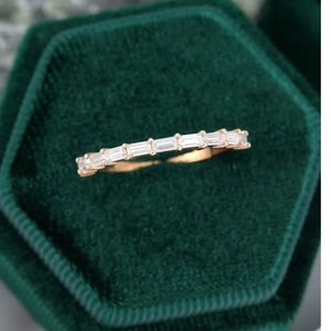 Può includere: Un delicato anello a fascia d'oro con una fila di piccoli diamanti di forma rettangolare.
