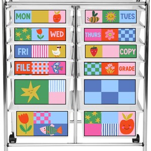 May include: A rolling metal storage cart with ten white plastic drawers. Each drawer front features colorful, patterned labels with illustrations of fruits, flowers, animals, and text including MON, TUES, WED, THURS, FRI, COPY, FILE, and GRADE.