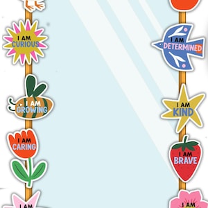 May include: A rectangular mirror with a yellow frame featuring the text AFFIRMATION STATION at the top. The border is decorated with colorful cutouts including a duck, apple, sun, bird, star, strawberry, flower, cloud, and fish with text.