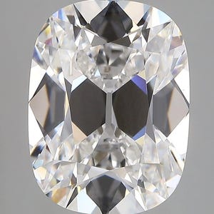 May include: A close-up of a cushion-cut diamond. The diamond is clear and colorless, with many facets that reflect light. The shape is rectangular with rounded corners. The diamond is set against a light gray background.